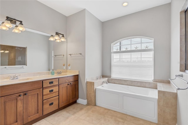 bathroom featuring a tub to relax in, vanity, and tile patterned floors