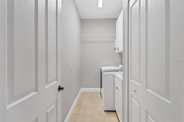 washroom featuring cabinets, washer and clothes dryer, and light tile patterned flooring