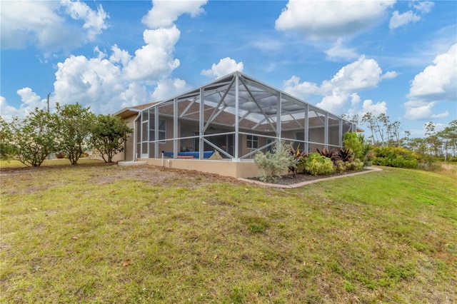 back of house featuring glass enclosure and a lawn