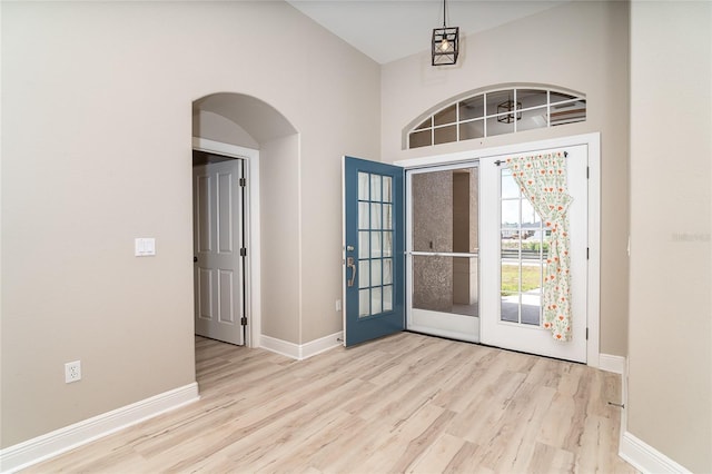 116 Hercules Dr, Rotonda West, FL 33947 - foyer entrance with wood finished floors, baseboards, arched walkways, and a high ceiling