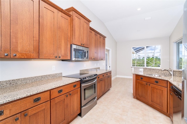 116 Hercules Dr, Rotonda West, FL 33947 - kitchen with appliances with stainless steel finishes, brown cabinets, vaulted ceiling, a sink, and light stone counters
