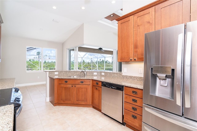 116 Hercules Dr, Rotonda West, FL 33947 - kitchen with appliances with stainless steel finishes, brown cabinetry, a sink, light stone countertops, and vaulted ceiling