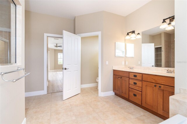 116 Hercules Dr, Rotonda West, FL 33947 - bathroom featuring toilet, double vanity, a ceiling fan, tile patterned floors, and baseboards
