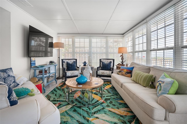 living room with a drop ceiling, visible vents, and tile patterned floors