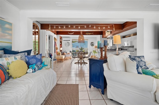 living room featuring light tile patterned floors, beam ceiling, visible vents, and a wealth of natural light