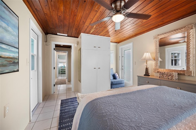 bedroom with light tile patterned floors, a closet, wood ceiling, and a ceiling fan