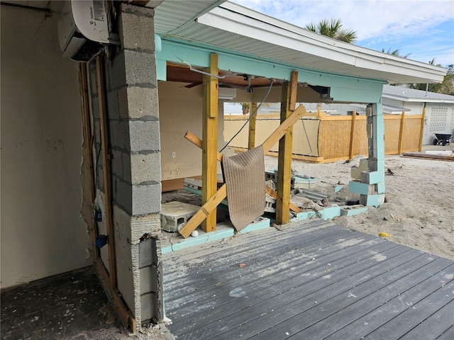 wooden deck with a wall mounted AC and fence