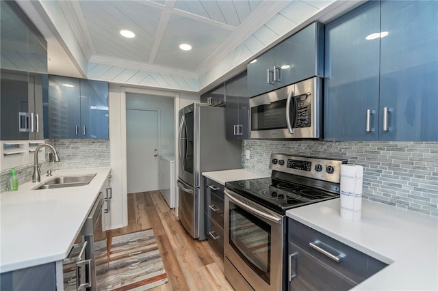 kitchen featuring stainless steel appliances, blue cabinetry, sink, and light hardwood / wood-style floors