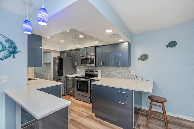 kitchen with stainless steel appliances, a kitchen breakfast bar, and kitchen peninsula