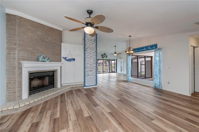 unfurnished living room with ceiling fan, a fireplace, and light hardwood / wood-style floors