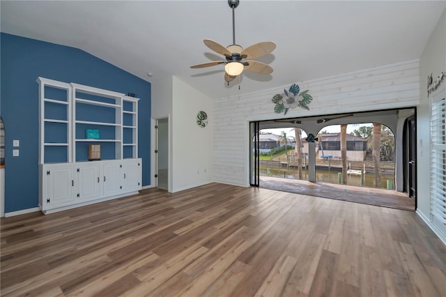 unfurnished living room featuring ceiling fan, vaulted ceiling, and wood-type flooring