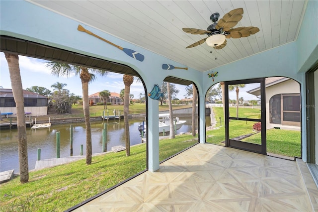 unfurnished sunroom featuring vaulted ceiling, a water view, and ceiling fan