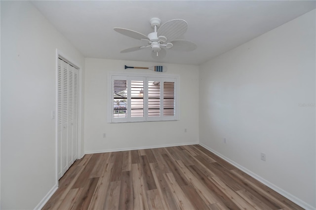 unfurnished bedroom featuring ceiling fan, a closet, and light wood-type flooring