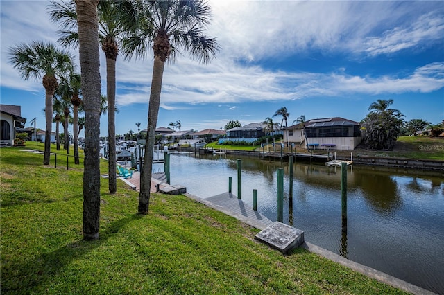 view of dock featuring a water view and a yard