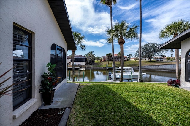 view of yard with a water view and a boat dock