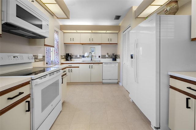 kitchen featuring white appliances, white cabinetry, and sink