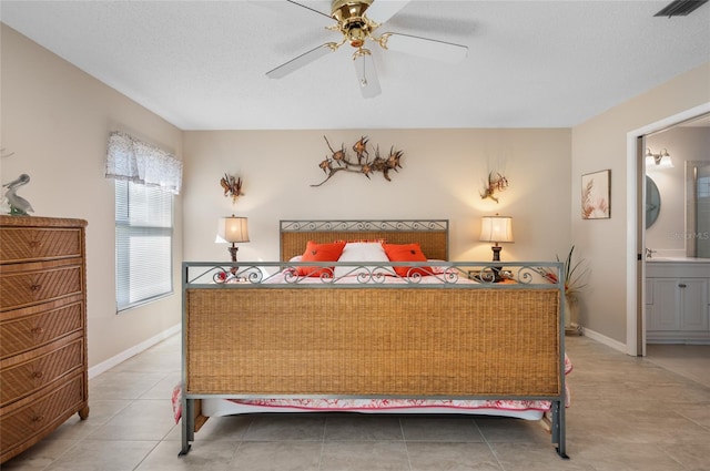 tiled bedroom with a textured ceiling, ceiling fan, and connected bathroom