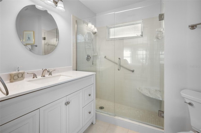 bathroom featuring toilet, tile patterned flooring, an enclosed shower, and vanity