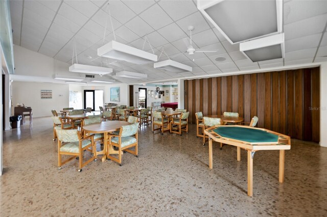 dining area with ceiling fan and a drop ceiling