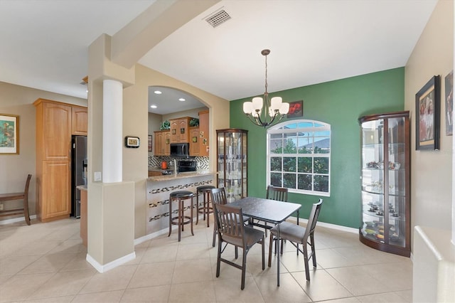 dining area with a notable chandelier and light tile patterned flooring