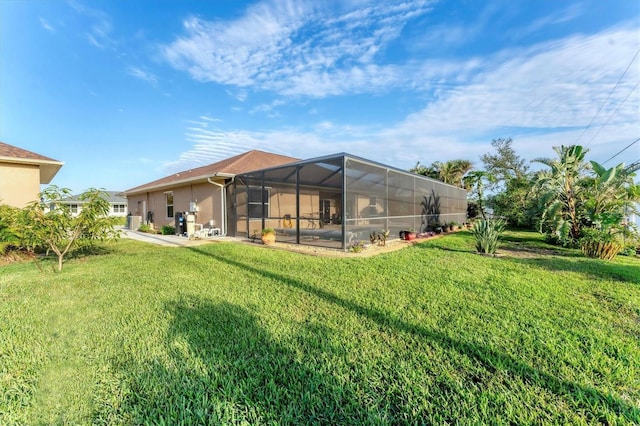 back of house with a lanai and a yard