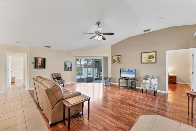 living room with ceiling fan, lofted ceiling, and light tile patterned floors