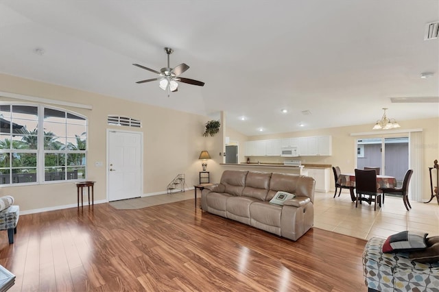 living room featuring light hardwood / wood-style flooring and ceiling fan with notable chandelier