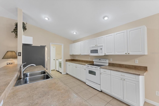 kitchen with white appliances, light tile patterned floors, lofted ceiling, white cabinets, and sink