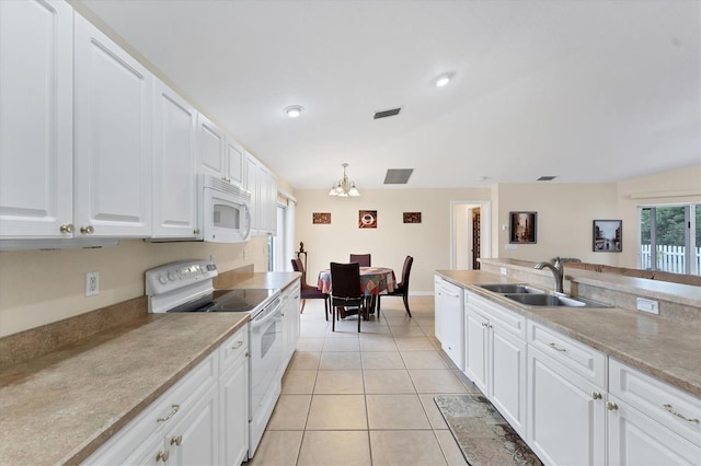 kitchen with sink, white appliances, white cabinetry, and hanging light fixtures