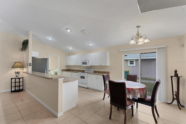 kitchen with white cabinets, an inviting chandelier, white appliances, light tile patterned flooring, and kitchen peninsula