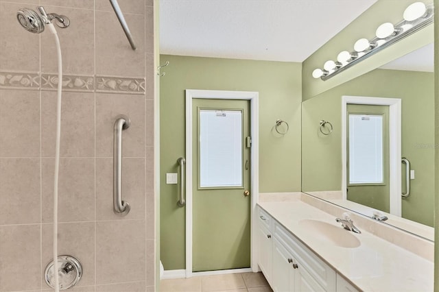 bathroom featuring vanity, tile patterned flooring, and tiled shower