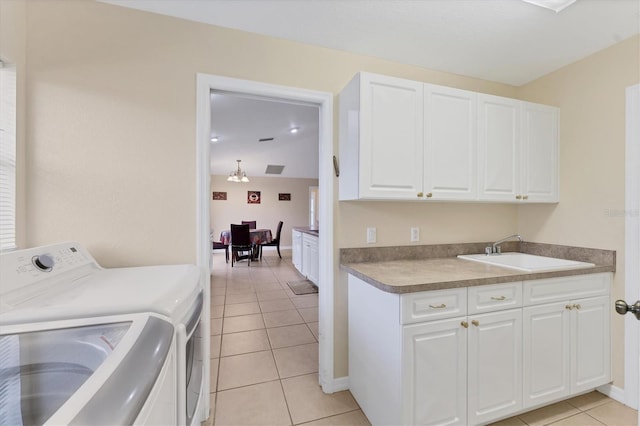 washroom featuring sink, cabinets, washing machine and dryer, and light tile patterned floors