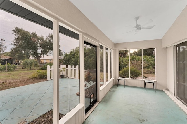 unfurnished sunroom with ceiling fan and vaulted ceiling