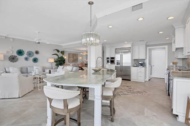 dining area featuring crown molding, sink, and ceiling fan with notable chandelier