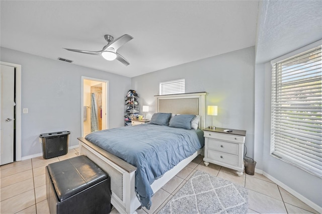 bedroom featuring ensuite bathroom, ceiling fan, and light tile patterned floors