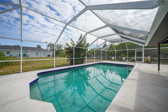 view of swimming pool featuring a yard, glass enclosure, and a patio area