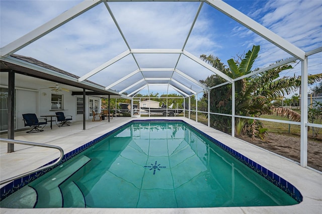 view of swimming pool featuring ceiling fan, a patio area, and glass enclosure