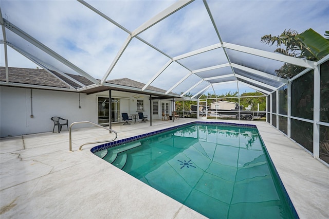 view of pool with ceiling fan, a patio area, and glass enclosure