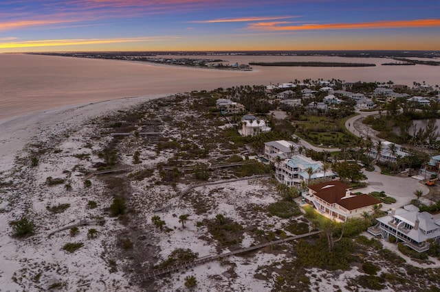 aerial view at dusk featuring a water view