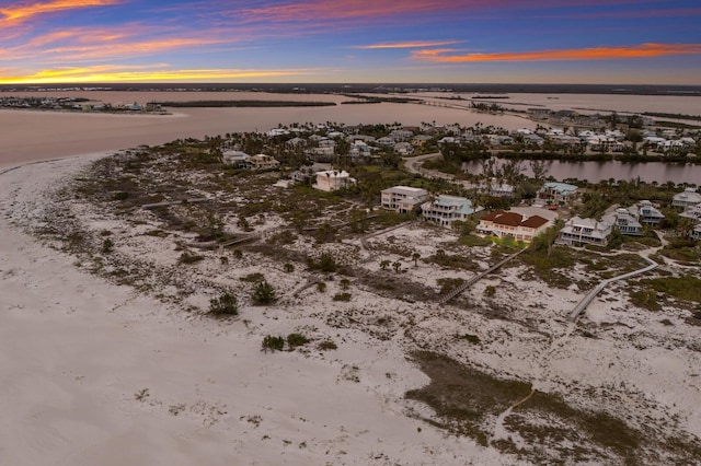 aerial view at dusk featuring a water view