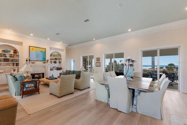 dining room featuring built in shelves and light hardwood / wood-style floors