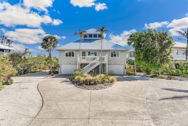 beach home featuring covered porch and a garage