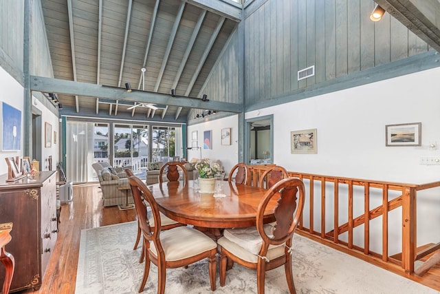 dining space featuring beam ceiling, wood ceiling, high vaulted ceiling, and wood-type flooring