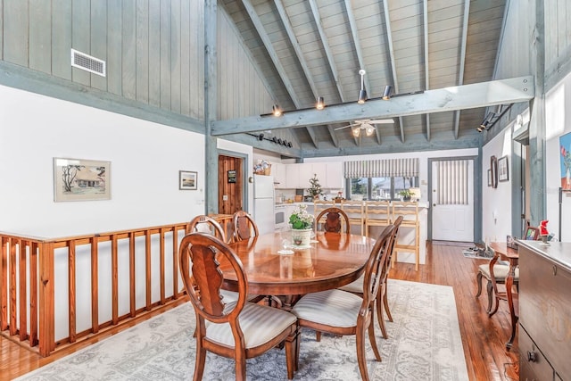 dining area with wooden ceiling, beamed ceiling, ceiling fan, light wood-type flooring, and high vaulted ceiling