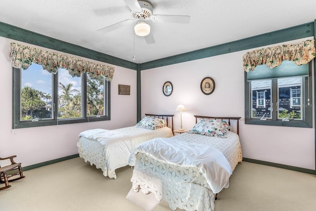 bedroom with ceiling fan, a textured ceiling, and carpet flooring