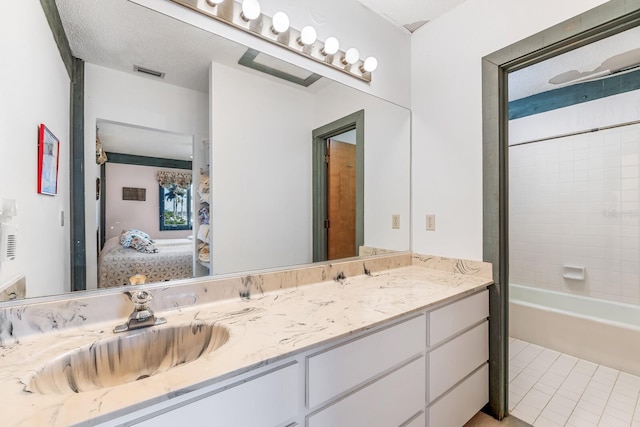 bathroom featuring vanity, tile patterned floors, and tiled shower / bath combo