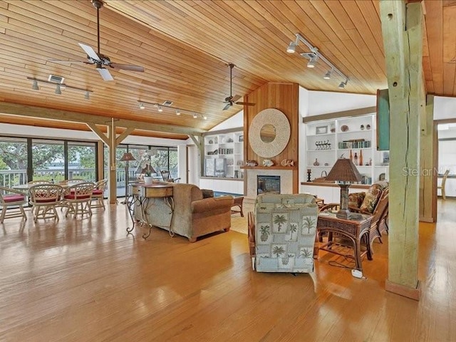 living room with wood ceiling, vaulted ceiling, built in shelves, and light hardwood / wood-style floors