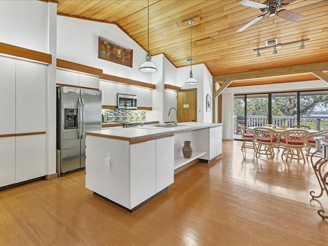 kitchen featuring appliances with stainless steel finishes, decorative light fixtures, white cabinetry, an island with sink, and wooden ceiling