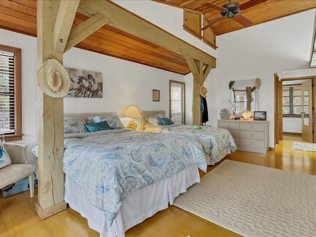 bedroom with high vaulted ceiling, wooden ceiling, beam ceiling, and light hardwood / wood-style flooring