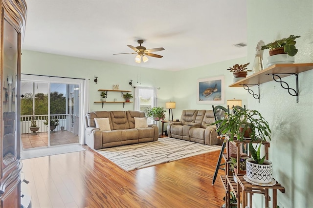 living room with wood-type flooring and ceiling fan